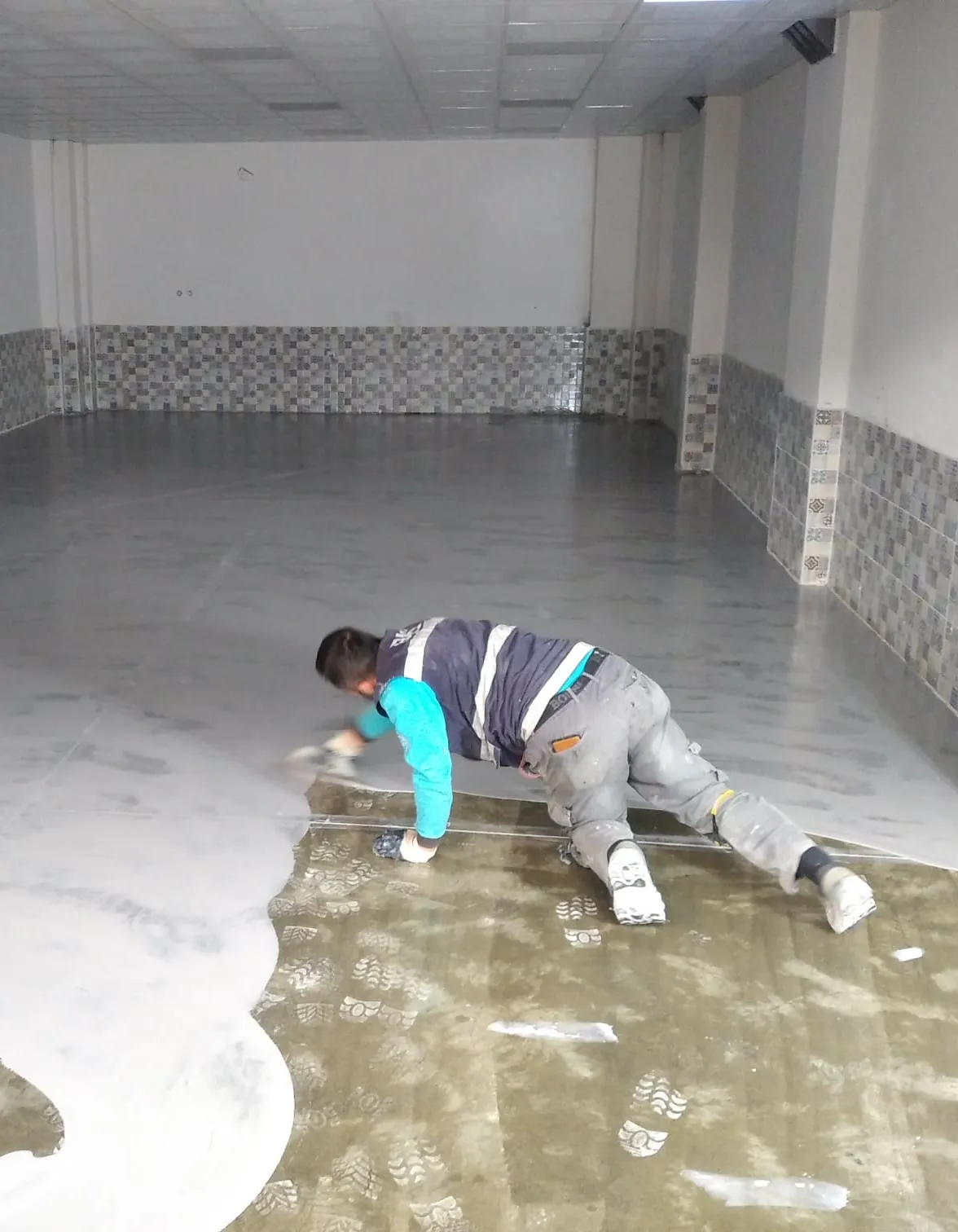 Dikey saha fotoğrafı: ekip iş başında, mala/rulo ile epoksi uygulaması